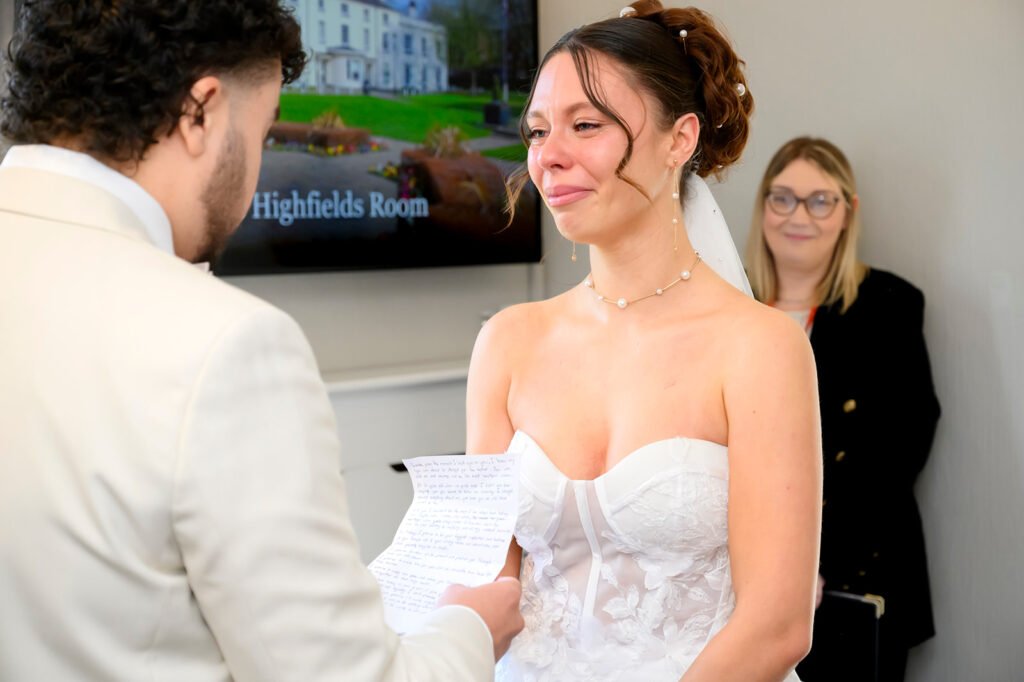 Bride and groom holding hands during wedding ceremony at Sandwell Register Office.
